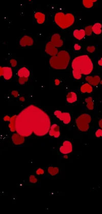 This beautiful phone live wallpaper features multiple red hearts floating in the air on a black background