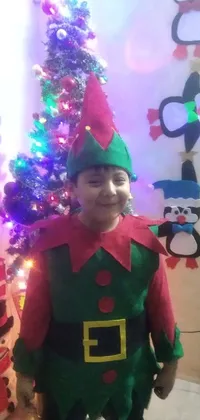 This phone live wallpaper features a festive scene with a boy in front of a decorated Christmas tree