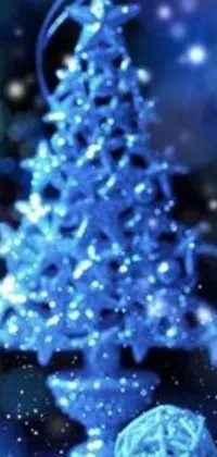 This stunning live wallpaper for your phone features a blue Christmas tree set against a snowy background