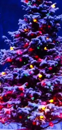 This live phone wallpaper features a stunning Christmas tree covered in snow, with colorful blinking lights and falling snowflakes adding a magical touch