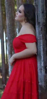 Looking for a stunning and unique phone wallpaper? Check out this fabulous live wallpaper! It features a gorgeous plus-size woman wearing a vibrant red dress, posing against a tree with a vintage vibe