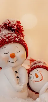 This live wallpaper depicts a pair of snowmen sitting together in a winter wonderland