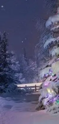 This phone live wallpaper portrays a beautiful Christmas tree standing tall in a snowy environment