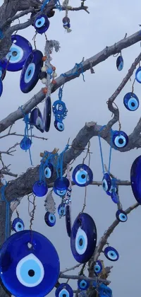 This vibrant live wallpaper features an eerie tree with unsettling eyes hanging from its branches