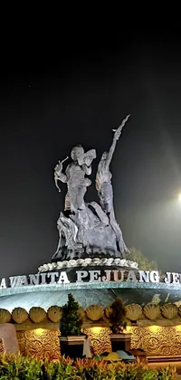 This dynamic live phone wallpaper depicts a high-quality photograph of a statue located in a park at night