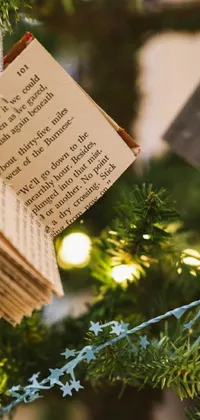 This live wallpaper showcases a splendid Christmas tree decor item in the form of a book ornament