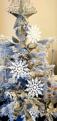 This live wallpaper for your phone features a beautiful silver Christmas tree that is decorated with snowflakes