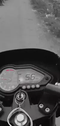 This dynamic phone live wallpaper depicts a striking black and white photograph of a motorcycle, taken from a distance to showcase the sense of freedom and adventure it represents