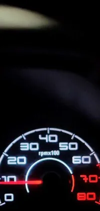 This sleek live wallpaper displays a close up view of a night-time car speedometer