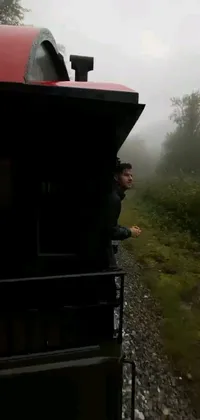 This live phone wallpaper features a mesmerizing scene of a train moving through a foggy and vast forest