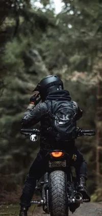 Get your motor running with this incredible live wallpaper! Featuring a mysterious man on a motorcycle, speeding down a dirt road in a dark forest, this wallpaper is sure to add a cool and edgy vibe to your phone's screen