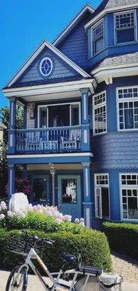 This phone live wallpaper showcases a vintage bicycle parked in front of a vibrant blue house, with a background displaying a charming seaside Victorian building, and a Craftsman-style home
