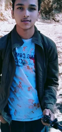 This phone live wallpaper features a young man holding scissors and a picture, standing in front of a mountain with floral clothes