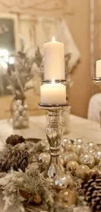 This live phone wallpaper features a cozy scene with two flickering candles on a rustic table surrounded by elegant silver ornaments that add a touch of sophistication