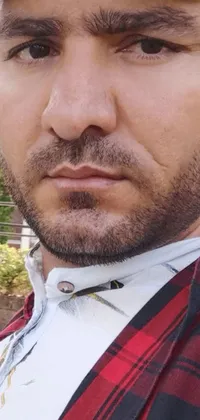 This phone live wallpaper showcases a close-up of an Afghan male with a salt and pepper goatee wearing a hat