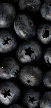 This phone live wallpaper features digital art of fresh blueberries up close, set against a night sky with shining stars