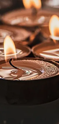 Enjoy the serene ambiance of a group of lit candles with this mesmerizing phone live wallpaper