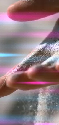 This stunning live phone wallpaper features a hand being sprinkled with sand, surrounded by vibrant holographic backgrounds and colorful kinetic pointillism dots