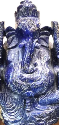 This stunning phone live wallpaper showcases a beautifully crafted blue statue of Vinayak on a wooden table