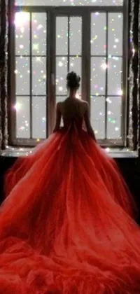 This phone live wallpaper features a stunning woman in a red dress, gazing out a window