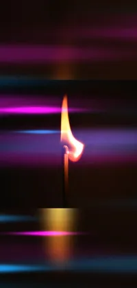 This stunning live phone wallpaper features a lit candle resting on a wooden table with a background of vibrant flames