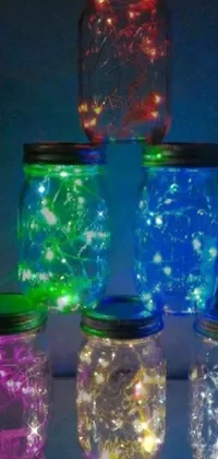 Looking for a stunning live wallpaper for your phone? Check out this beautiful artwork featuring a group of mason jars on a table, surrounded by electric blue fireflies! The jars are exquisitely designed and light up in vibrant colors that fade and change with each swipe of your phone