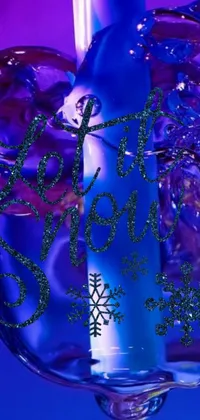 This stunning phone live wallpaper features a blue candle on a glass vase, an album cover, Instagram graffiti, snowflakes, and a violet-colored theme