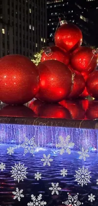 This Christmas-themed phone live wallpaper showcases a group of red balls atop a stunning fountain in Madison Square Garden