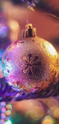 This phone live wallpaper showcases a stunning close-up of a Christmas ornament with intricate patterns and curves, set against a background of silver light
