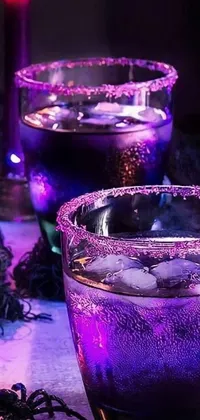 This live phone wallpaper depicts two stunning glasses filled with purple liquid on a table