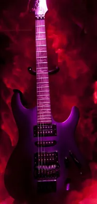 This vivid phone live wallpaper features a striking purple electric guitar resting on a table, with a red and mangeta smoke trailing around