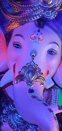 This phone live wallpaper is a dazzling image of a majestic elephant statue with bright LED eyes set against a colorful backdrop