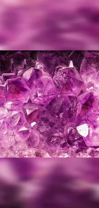 This stunning live wallpaper features a macro shot of a luminous pile of purple crystals sitting on a table