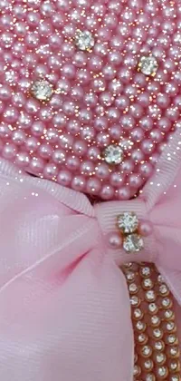 This stunning live wallpaper features a beautiful pink bow adorned with pearls and delicate floral patterns