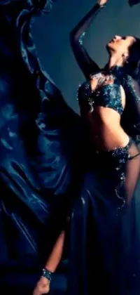 This phone live wallpaper features a woman dancing in a black dress with her exposed belly button and a luxurious silk cloak