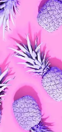 This phone wallpaper boasts a lively pink background highlighted by vivid purple pineapples