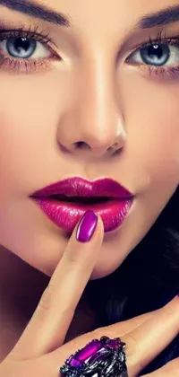 This phone live wallpaper features a hyper-realistic close-up of a woman's stylish purple lipstick and a chic ring on her finger