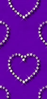 This phone live wallpaper features sparkling diamond hearts against a vibrant purple background
