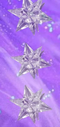 This live wallpaper for phones showcases three glittering crystal stars set against an enchanting violet backdrop
