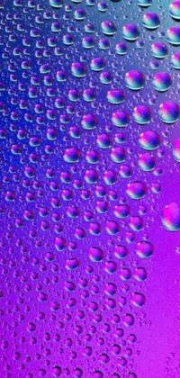 This phone live wallpaper features a mesmerizing close-up of water droplets on a captivating background consisting of purple and blue hues