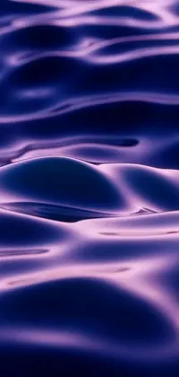 Introducing a stunning live wallpaper for your phone featuring a beautiful body of water with gentle waves and a microscopic photo of liquid purple metal