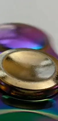 This stunning phone live wallpaper showcases a vivid and colorful fidgeter sitting on a gleaming metallic table