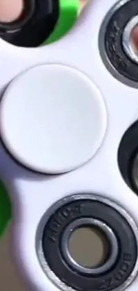 This live wallpaper features a close-up shot of a hand holding a white spinner with black spots