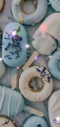 This live wallpaper brings your phone screen to life with a tantalizing display of frosted donuts, digital art, and colorful accents