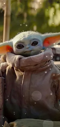 This live wallpaper for phones showcases a high definition close-up of a stuffed Baby Yoda, the well-known character from "The Mandalorian" TV series from Lucasfilm