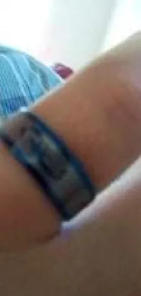 This live wallpaper features a close-up of a hand holding a cell phone with a blue jewelry cover and a Nordic wedding ring