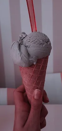 This live wallpaper features a close up of a hand holding an ice cream cone, with milkshake drips sliding down