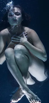 This phone live wallpaper showcases a stunning hyper-realistic image of an underwater woman holding a cellphone