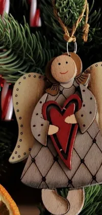 This Christmas-themed phone live wallpaper features a charming wooden angel ornament hanging from a beautifully decorated tree, adorned with colorful holiday décor