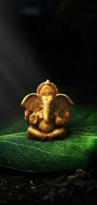 Looking for a stunning phone live wallpaper? This vivid image features a detailed statue of an elephant sitting atop a large leaf, believed to represent Lord Ganesha, the Hindu god of wisdom and prosperity